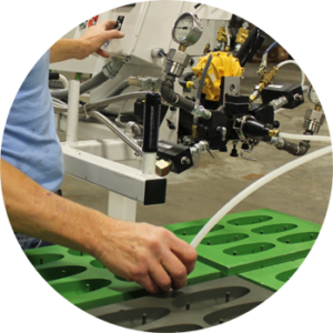 Green and black Sorbothane material being used in manufacturing equipment with a worker in a blue shirt.