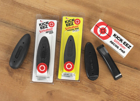 Packaged and unpackaged black KICK-EEZ Recoil Reducing Pads made with Sorbothane material displayed on a wooden table