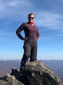 woman standing on top of mountain after hike